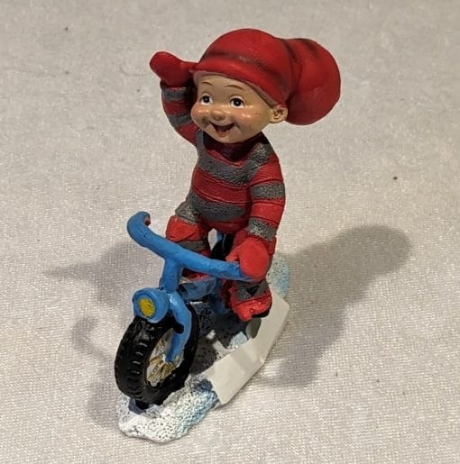 Babynisse gutt sykler mens han vinker