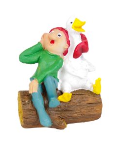 Brammingnisse i grønt og blåt tøj der sidder sammen med en hvid gås på træstamme